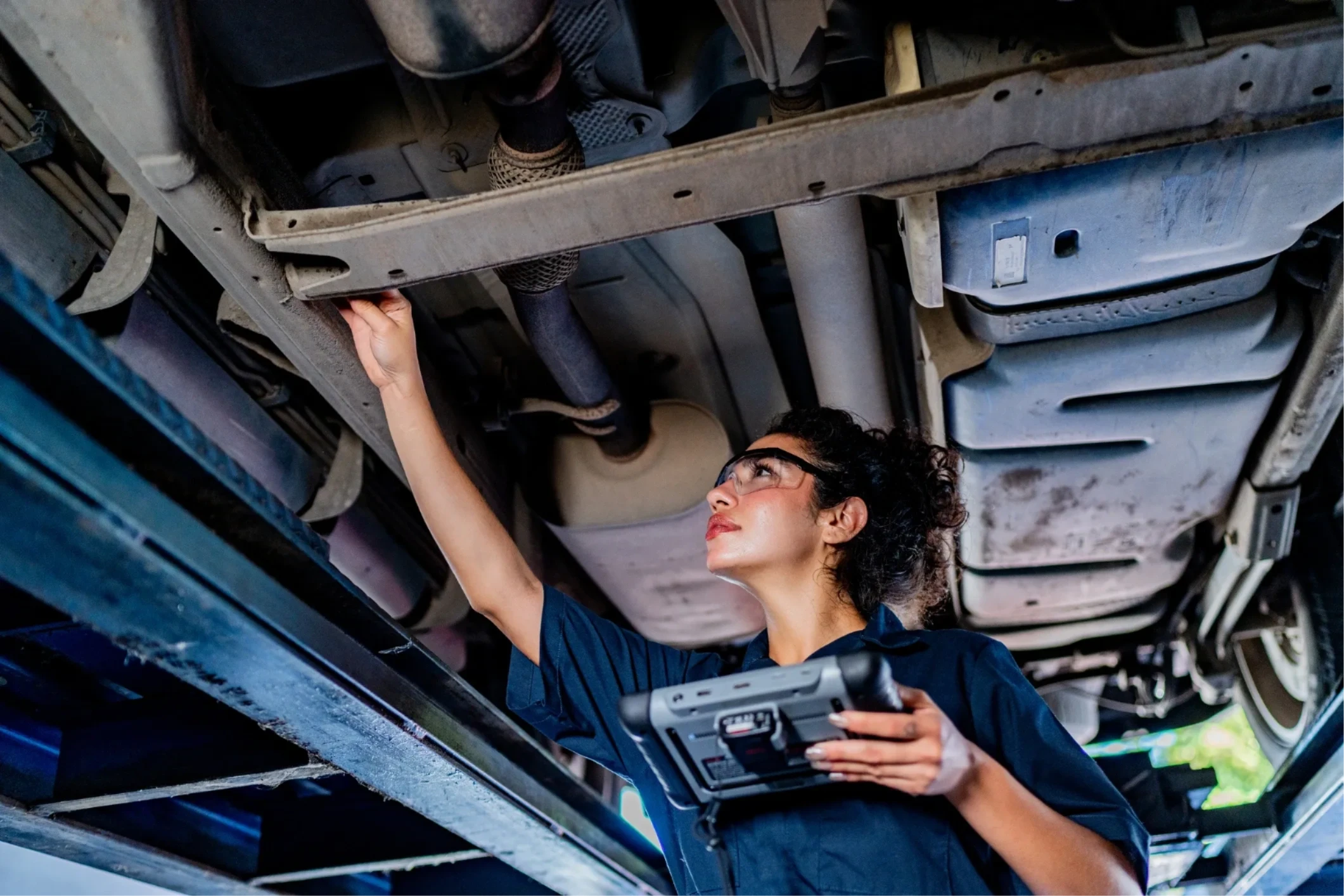 Mechanic performing MOT inspection on a vehicle